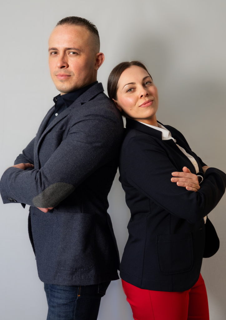 Two professionals standing back-to-back with arms crossed