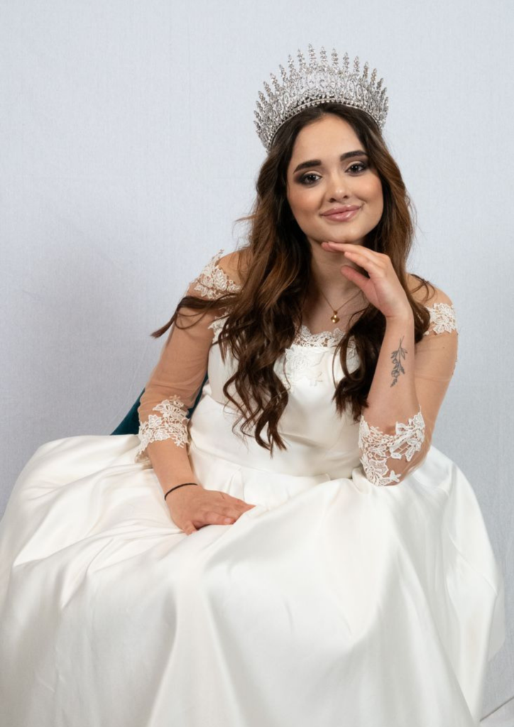 Young woman in a white dress with a crown